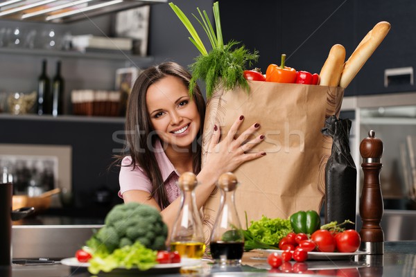 Young woman with grocery bag full of fresh vegetables on a modern kitchen Stock photo © Nejron