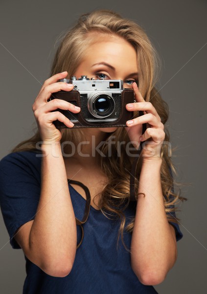 Positive young woman with long hair and blue eyes holding vintage style camera Stock photo © Nejron