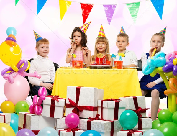 Stock photo: Croup of happy children celebrating birthday behind table 