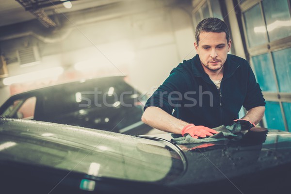 Cheerful worker wiping car on a car wash Stock photo © Nejron