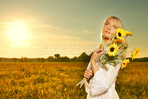 Jovem bela mulher buquê girassóis campo pôr do sol Foto stock © Nejron