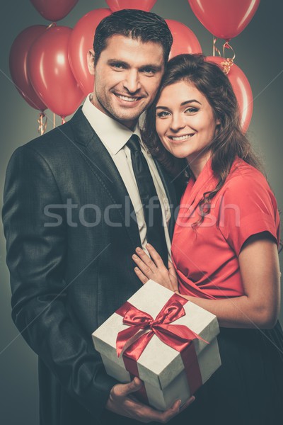 Stock photo: Happy couple with balloons and gift box