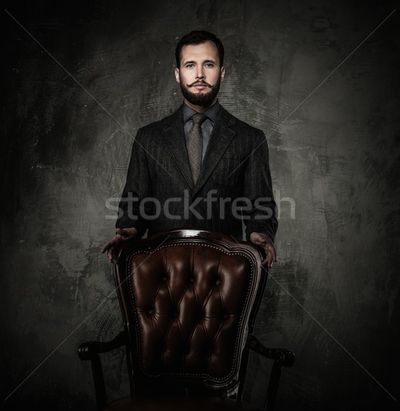 Handsome well-dressed  standing near leather chair  Stock photo © Nejron