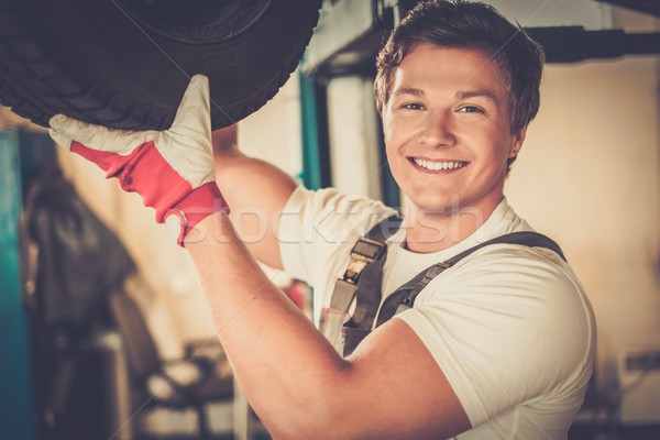Cheerful serviceman checking suspension in a car workshop  Stock photo © Nejron
