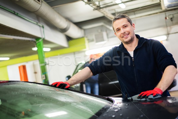 Cheerful worker wiping car on a car wash Stock photo © Nejron