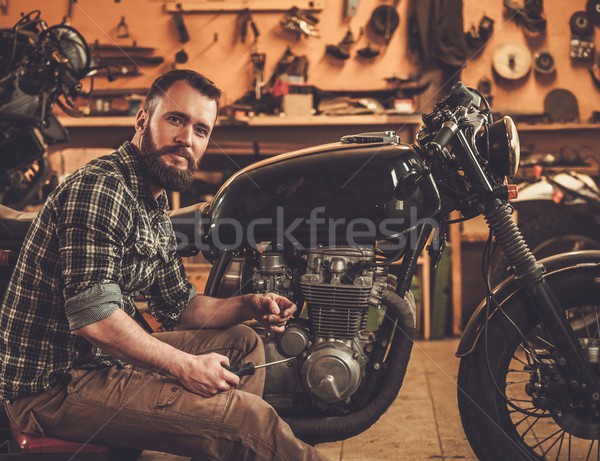 Mechanic building vintage style cafe-racer motorcycle  in custom garage Stock photo © Nejron