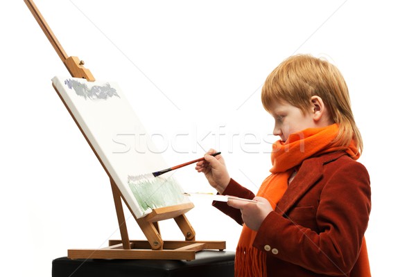 Little redhead boy drawing picture on an easel Stock photo © Nejron