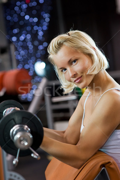 Stock photo: Strong beautiful woman lifting heavy weights