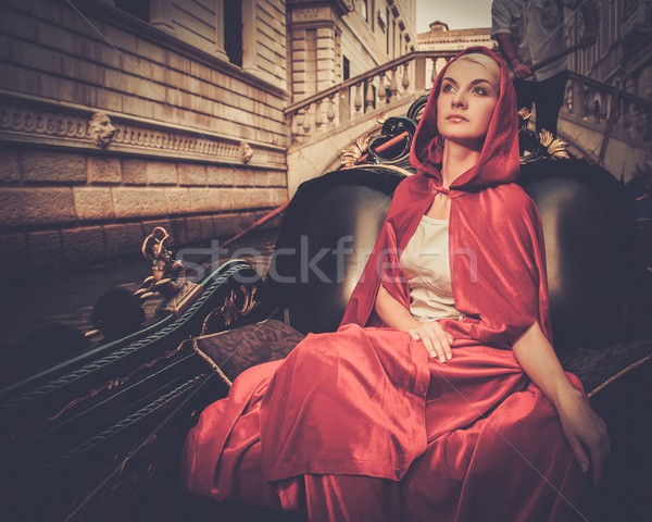 Gyönyörű nő piros köpeny lovaglás gondola víz Stock fotó © Nejron