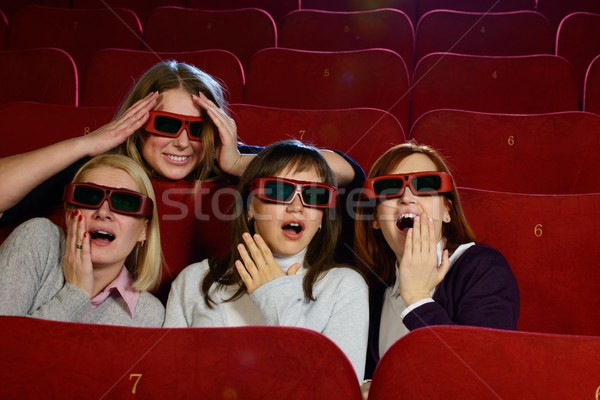 Group of excited young girls watching movie in cinema Stock photo © Nejron