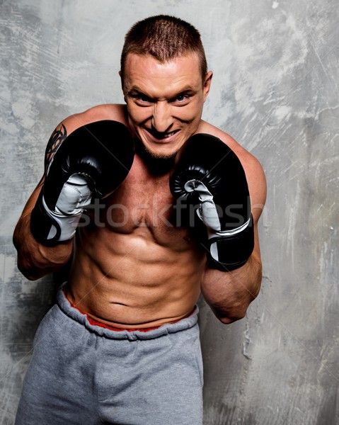 Young sporty man in boxing gloves posing  Stock photo © Nejron