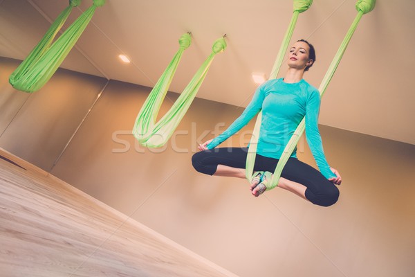 Young woman performing antigravity yoga exercise  Stock photo © Nejron