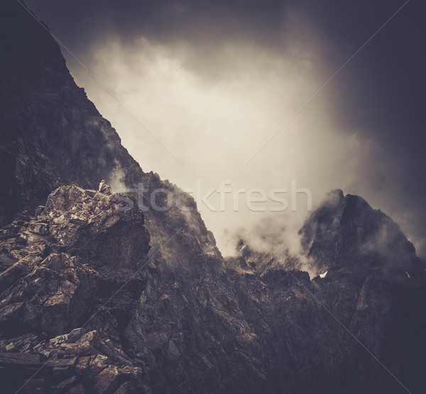 Woman hiker sitting on a mountain peak  Stock photo © Nejron