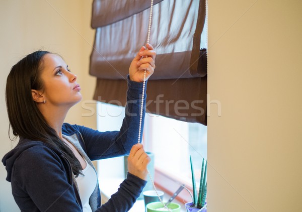 Young woman opening jalousie in her apartment Stock photo © Nejron