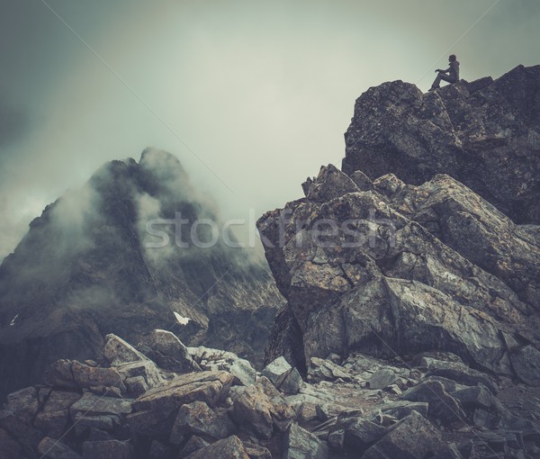 Woman hiker sitting on a mountain peak  Stock photo © Nejron