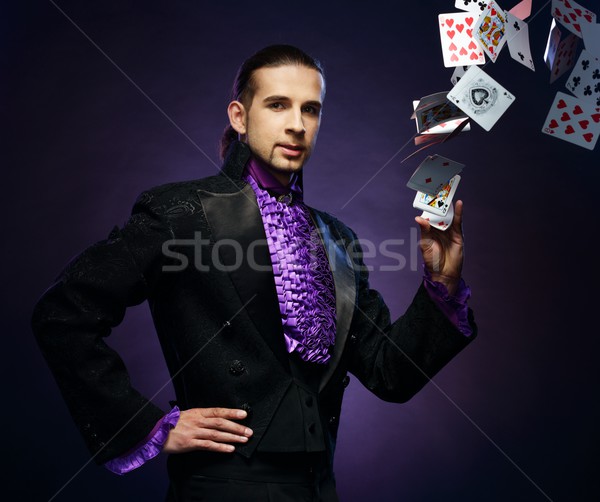 Young brunette magician in stage costume showing card tricks  Stock photo © Nejron