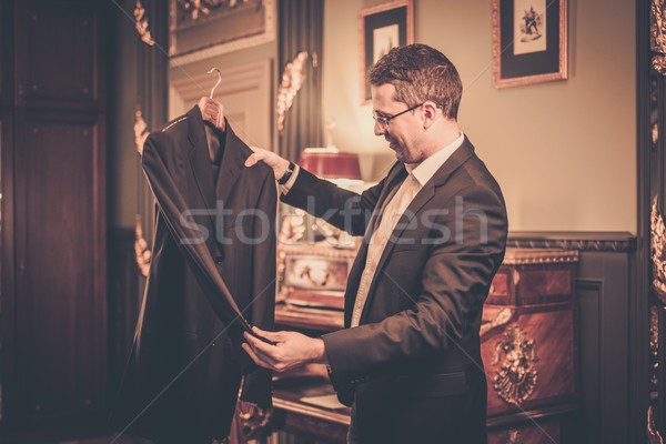 Człowiek patrząc garnitur wieszak działalności Zdjęcia stock © Nejron