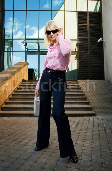 Beautiful young woman with silver case near the modern office bu Stock photo © Nejron