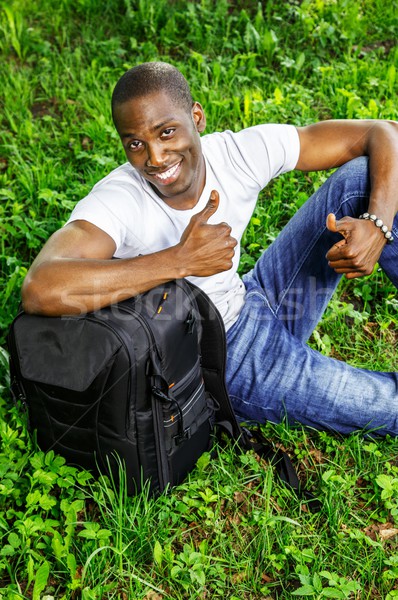 Young smiling african american man with rucksack in a park Stock photo © Nejron