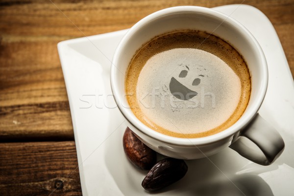 Coffee cup on a wooden table with smiley in it Stock photo © Nejron