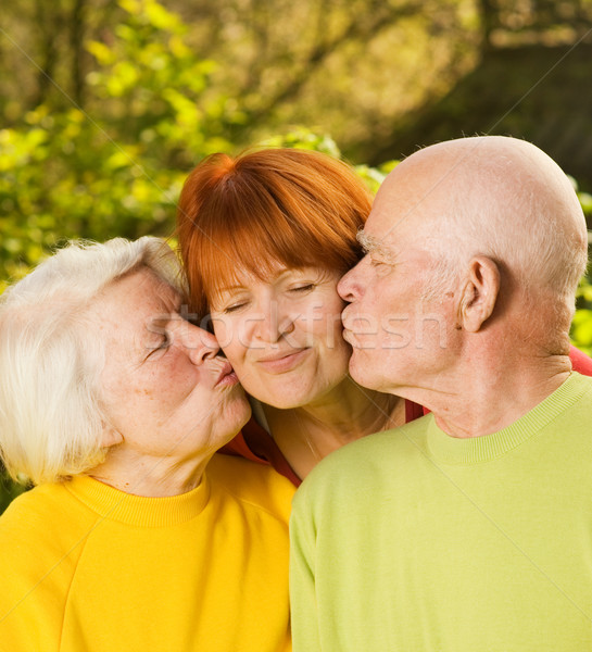 Senior parents kissing their daughter outdoors Stock photo © Nejron