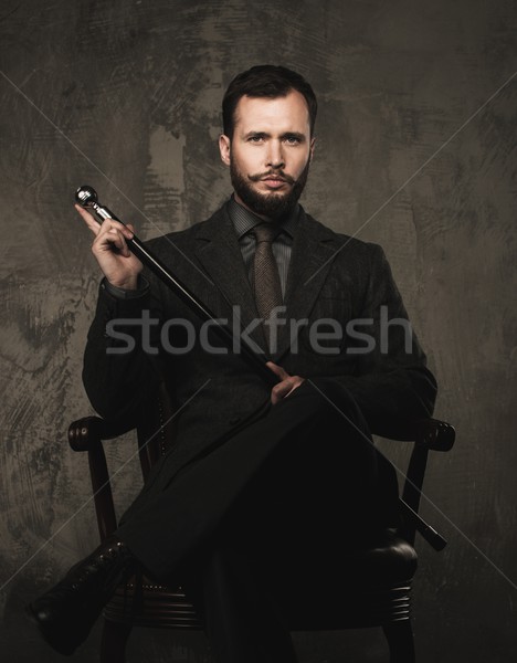 Handsome well-dressed with stick sitting in leather chair  Stock photo © Nejron
