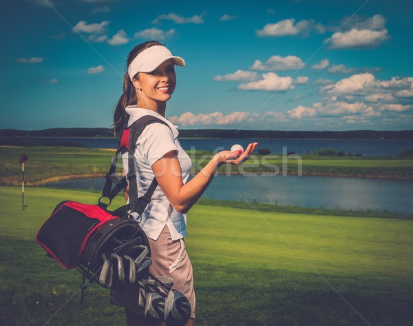 Young cheerful woman with bag and ball on a golf field Stock photo © Nejron