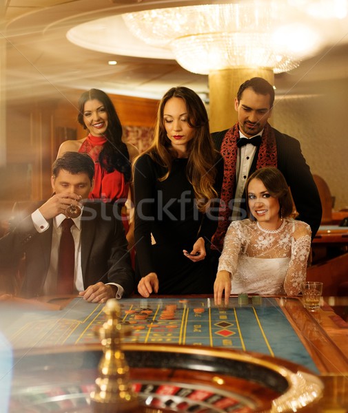 Group of young people behind roulette table in a casino Stock photo © Nejron