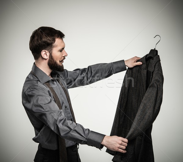 Handsome man with beard choosing jacket  Stock photo © Nejron