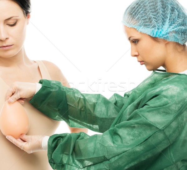 Plastic surgeon woman trying on silicon breast implant on potential client  Stock photo © Nejron