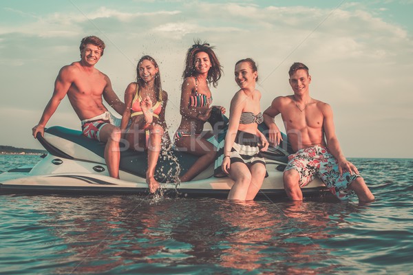 Group of multi ethnic friends sitting on a jet ski Stock photo © Nejron