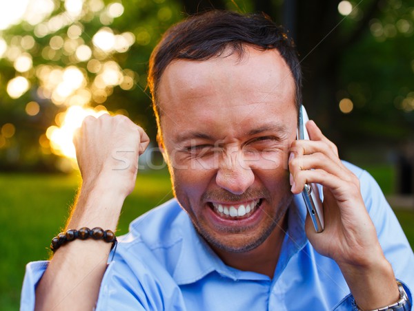 Happy handsome middle-aged man with mobile phone outdoors  Stock photo © Nejron