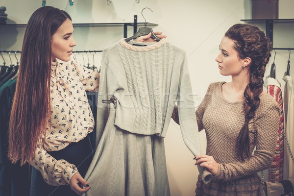 Young woman choosing clothes on a rack in a showroom  Stock photo © Nejron