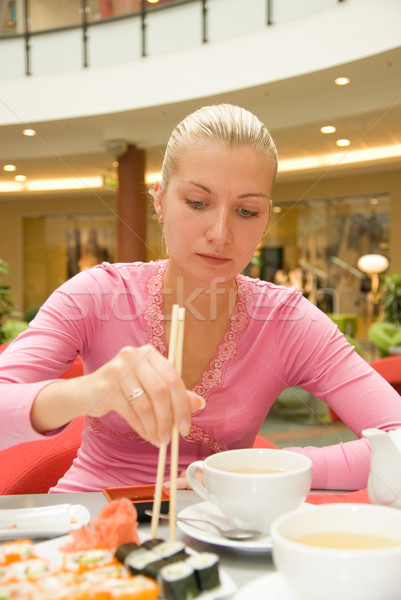Girl eating sushi in a restaurant Stock photo © Nejron
