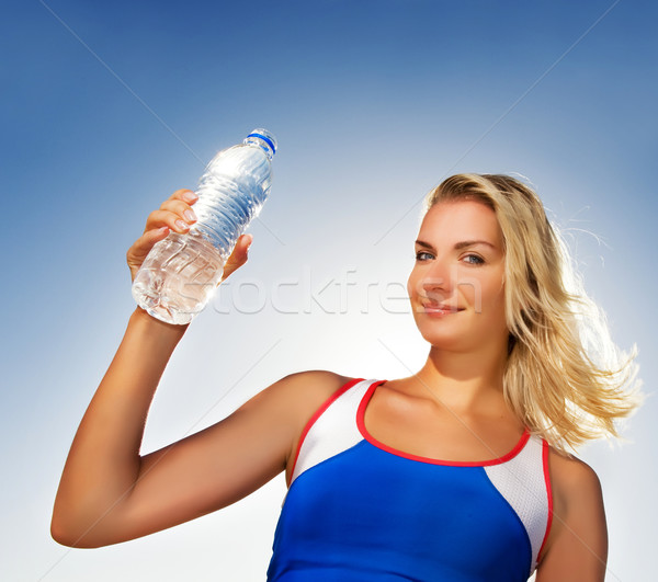 Young woman drinking water after fitness exercise Stock photo © Nejron
