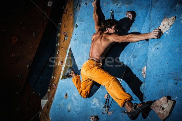 Muscular man practicing rock-climbing on a rock wall indoors  Stock photo © Nejron