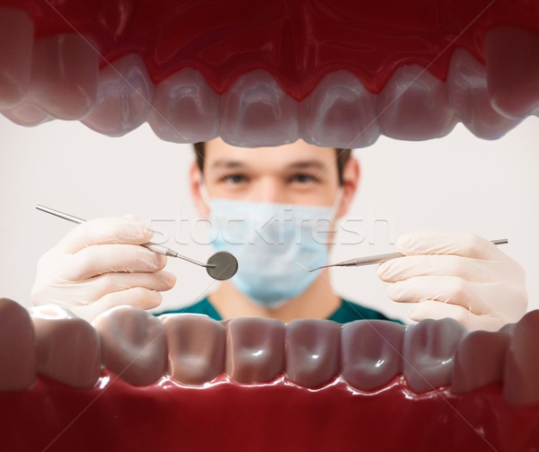 View at young male dentist holding dental tools from patient mouth  Stock photo © Nejron