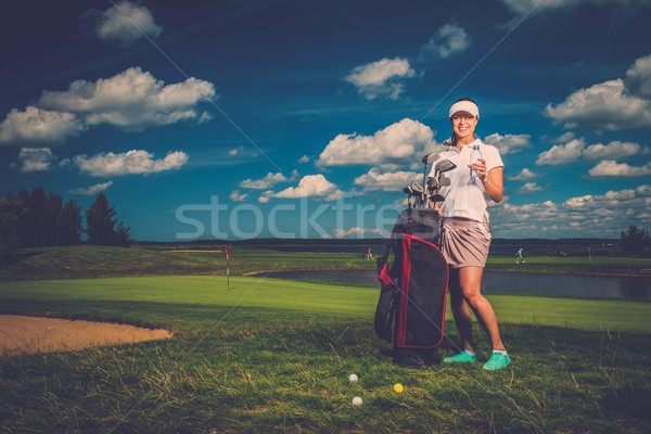 Young cheerful woman with bag and bottle of water on a golf field Stock photo © Nejron