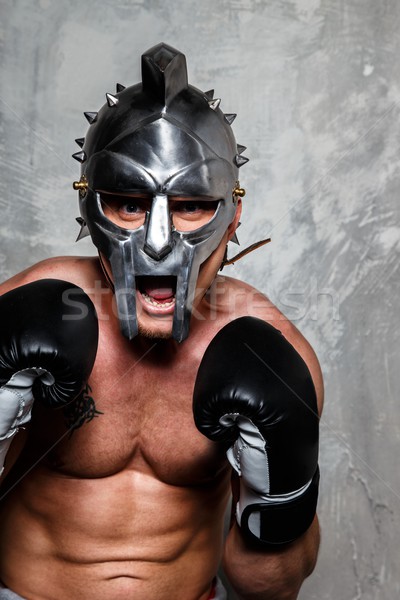 Jeune homme gants de boxe gladiator casque posant sport Photo stock © Nejron