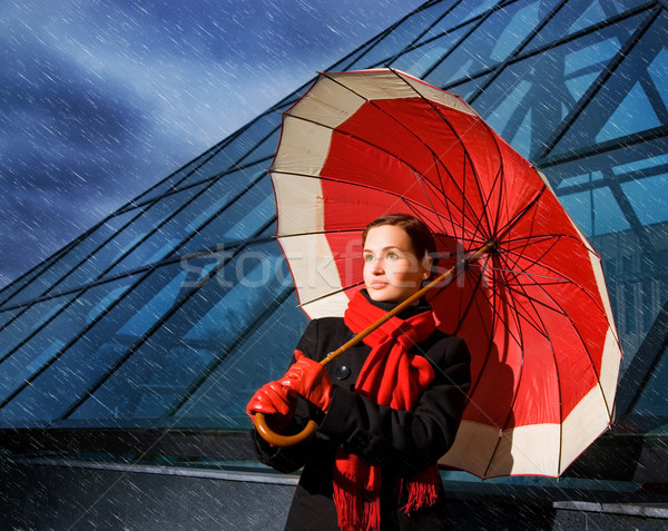 Beautiful young woman with red umbrella on rainy day Stock photo © Nejron