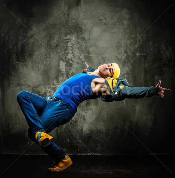 Man dancer in cap and jacket showing break-dancing moves Stock photo © Nejron