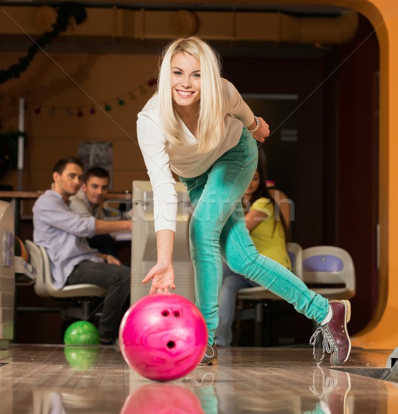People watching young blond woman throwing bowling ball Stock photo © Nejron