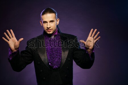 Young handsome brunette magician in stage costume  Stock photo © Nejron
