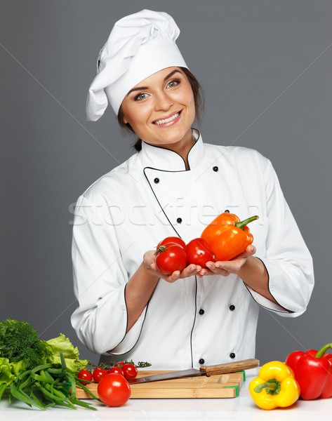 Beautiful young woman cook with fresh tomatoes and paprika Stock photo © Nejron