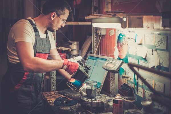 Serviceman mixing paint in a car body workshop Stock photo © Nejron