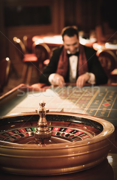 Man in suit and scarf playing roulette in a casino Stock photo © Nejron