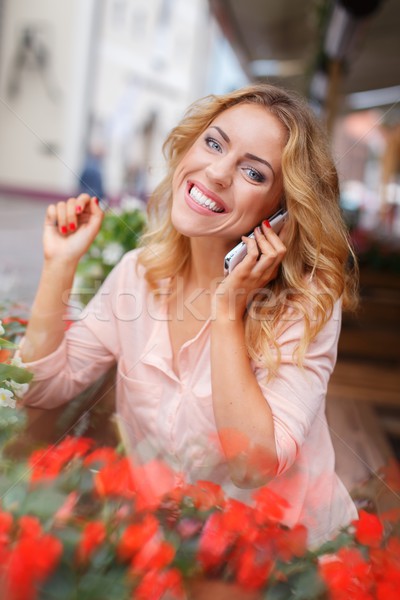 笑みを浮かべて 若い女性 携帯電話 花 夏 テラス ストックフォト © Nejron