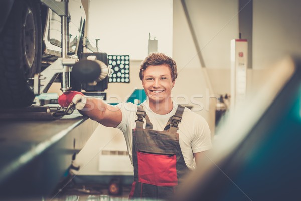 Serviceman checking wheel alignment  in a car workshop  Stock photo © Nejron