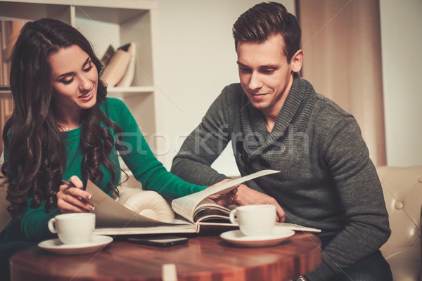 Young man and woman with book and coffee behind table  Stock photo © Nejron