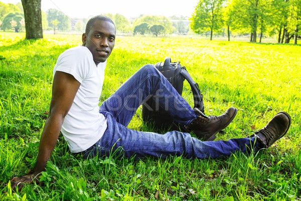Young african american man in white shirt  with rucksack in a park Stock photo © Nejron